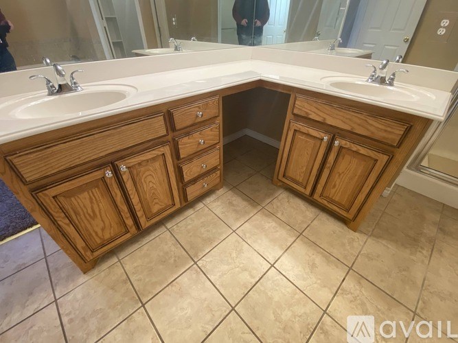 A bathroom with two sinks and wooden cabinets.