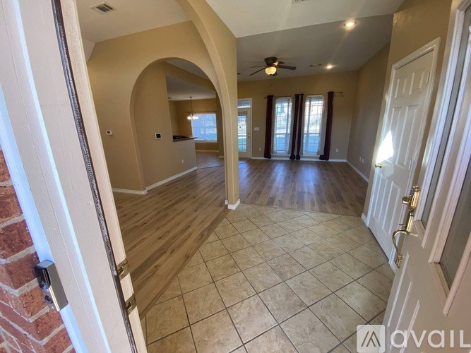 A spacious room with a tiled floor and a ceiling fan.