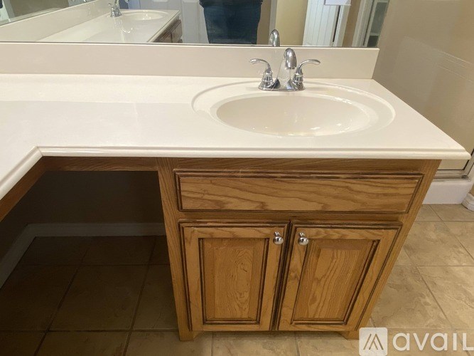 A bathroom sink with a wooden cabinet below it.