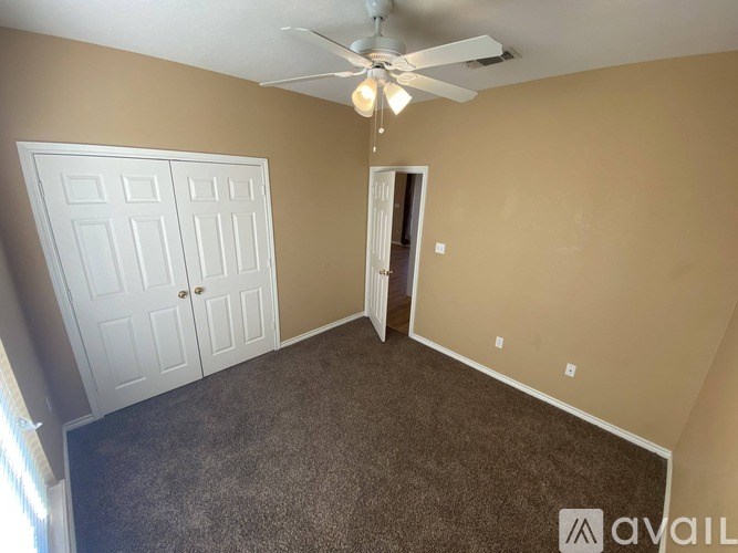 A room with a ceiling fan and two doors.
