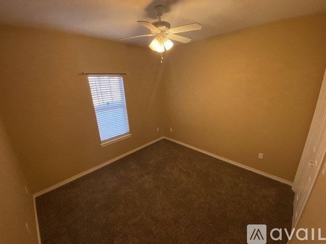 A room with a ceiling fan and a window with blinds.