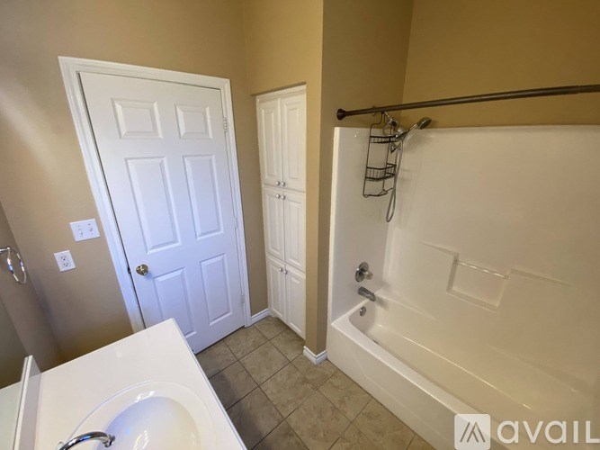 A bathroom with a white tub and a white door.