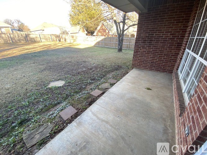 A concrete pathway leads from a house to a grassy area.