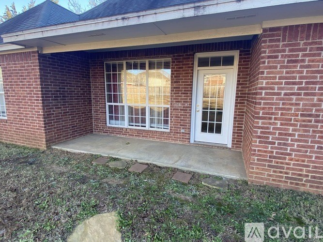 A brick house with a white door and windows.