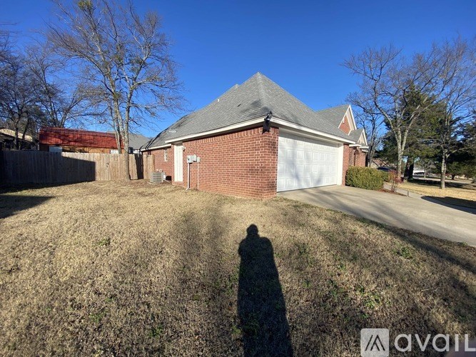 A house with a garage is situated in a grassy area.
