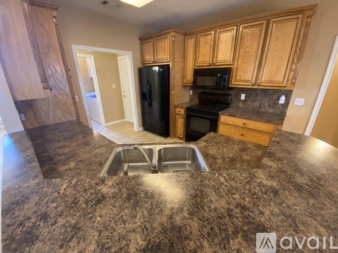 A kitchen with granite countertops and wooden cabinets.