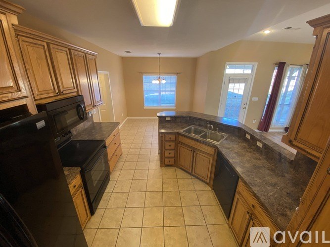 A kitchen with wooden cabinets and black appliances.