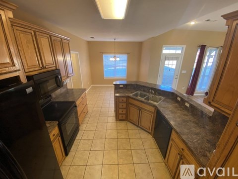 A kitchen with wooden cabinets and black appliances.