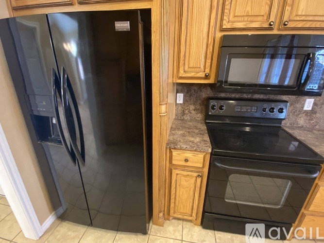 A kitchen with a black oven and a black microwave.