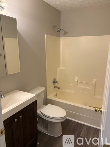 A bathroom with a toilet, sink, and bathtub.