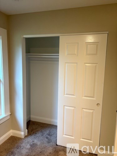 A white door is in a room with a carpet.