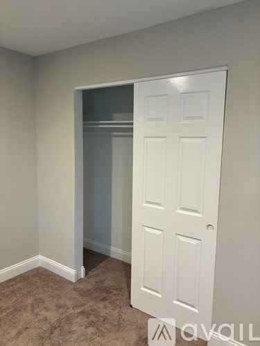 A white door is in a room with carpeted flooring.