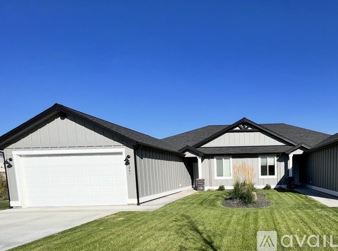 A house with a garage and a driveway is available for sale.