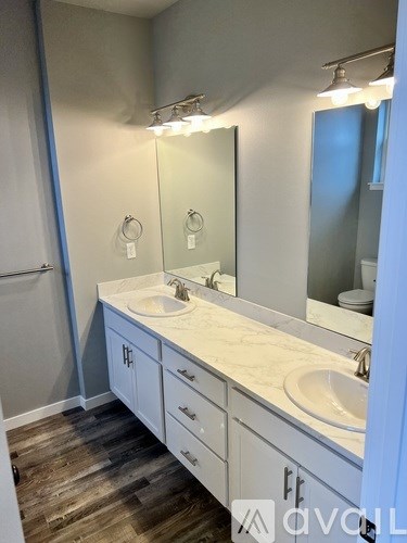A bathroom with a sink, mirror, and cabinets.