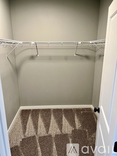 A small, empty room with a carpeted floor and a white door.