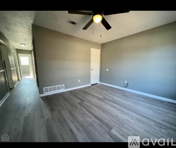A room with wooden flooring and a ceiling fan.