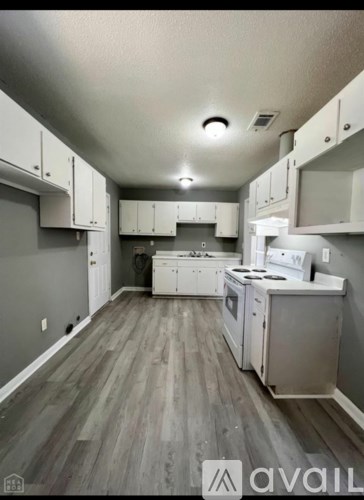 A kitchen with white appliances and cabinets.