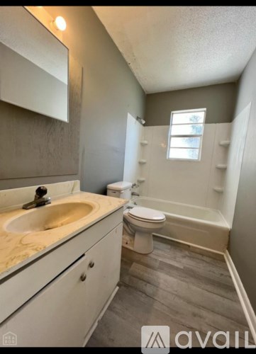 A bathroom with a sink, toilet, and bathtub.