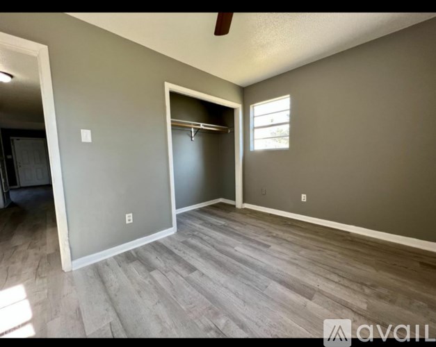 A room with a grey wall and a wooden floor.