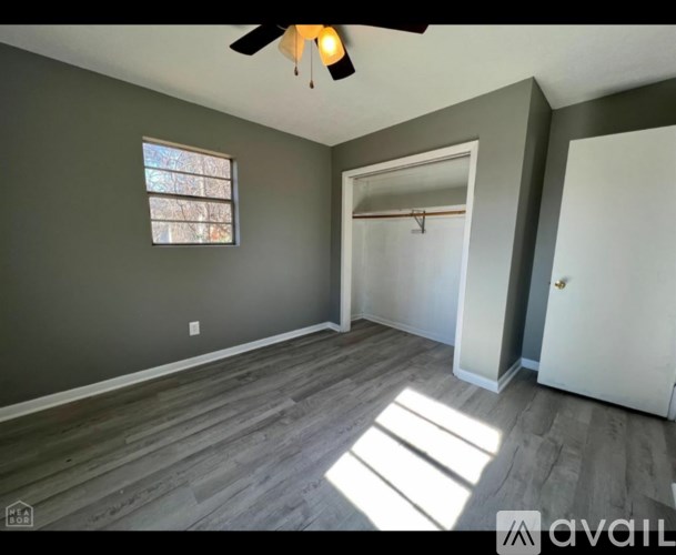 A room with a ceiling fan and a window.