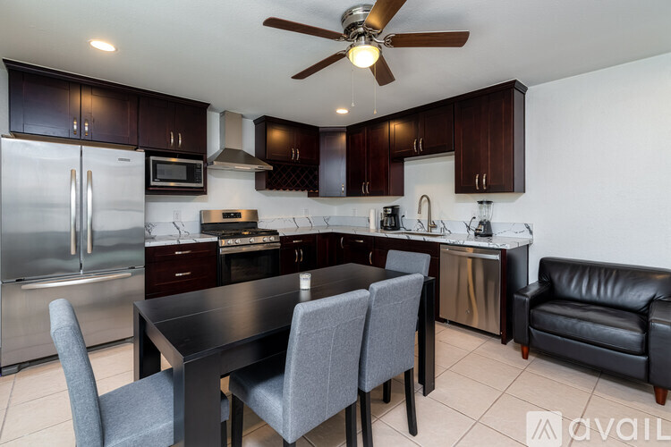 A kitchen with a table and chairs and a refrigerator.