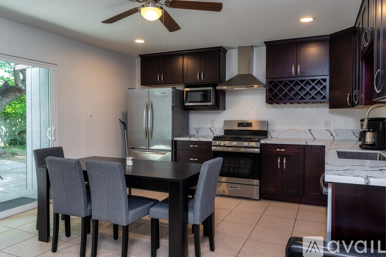 A kitchen with a table and chairs.