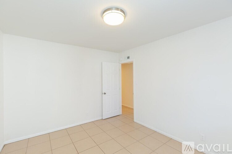 A room with a white door and a light on the ceiling.