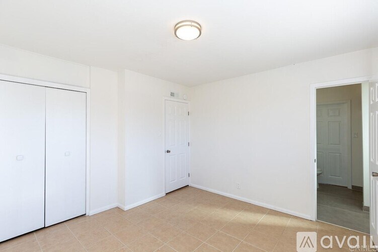 A room with white walls and a beige carpet.