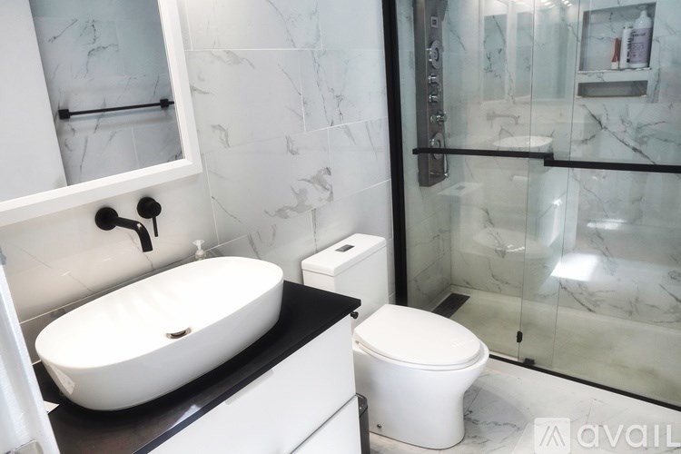 A white toilet sits next to a sink in a bathroom.