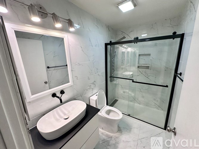 A bathroom with a sink, toilet, and shower.