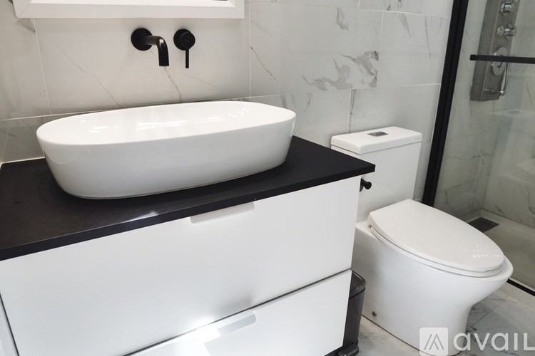 A white sink is on a black countertop in a bathroom.
