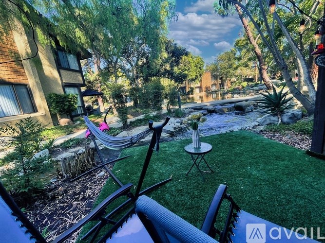 A backyard with a hammock and a small table.