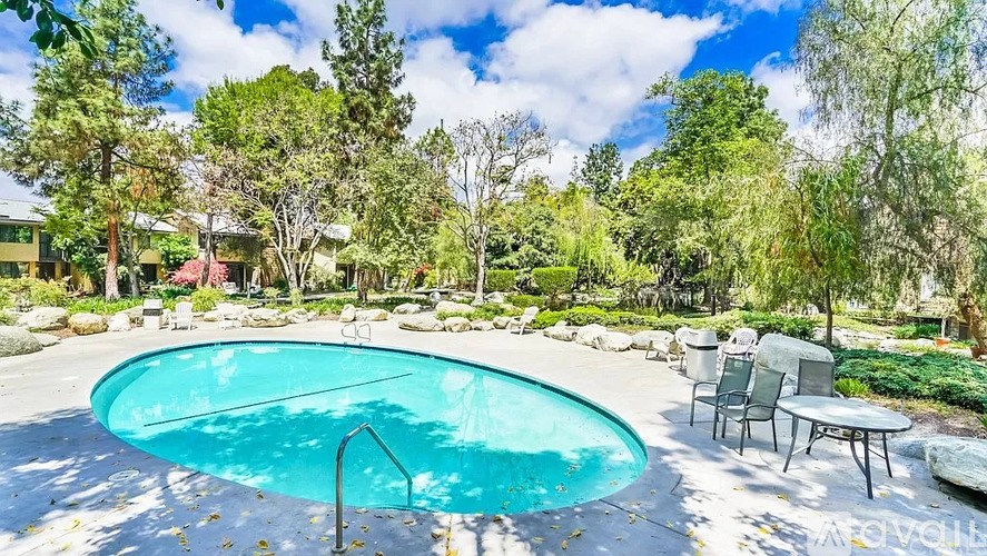 A small round above ground pool with a table and chairs around it.