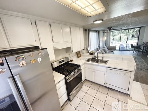 A kitchen with white cabinets and a stainless steel refrigerator.