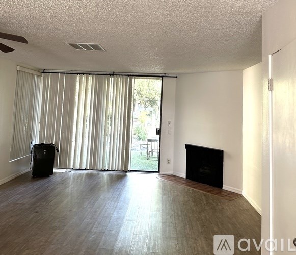 A room with a fireplace and sliding glass doors.