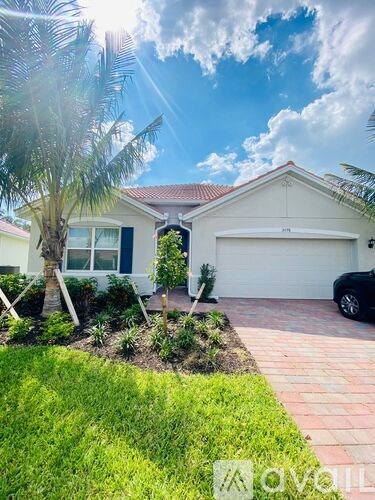 A house with a white exterior and a red roof with a driveway and a car.