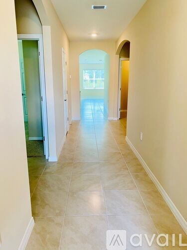 A long hallway with tiled floors and white walls.