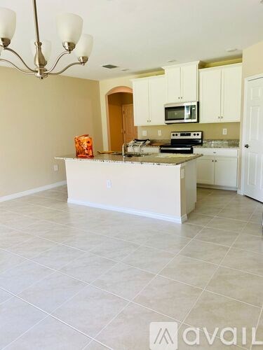 A kitchen with white appliances and cabinets.