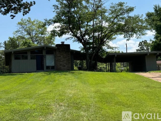A house with a green lawn in front of it.