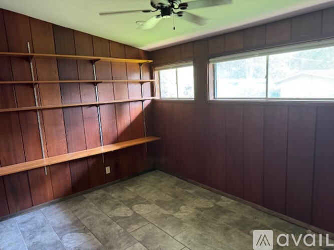 A room with wooden walls and a ceiling fan.