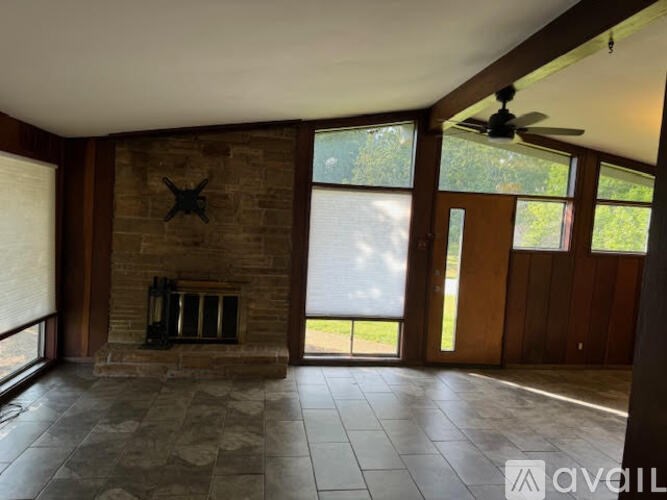 A living room with a fireplace and a fan.