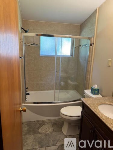 A bathroom with a toilet, sink, and walk-in shower.