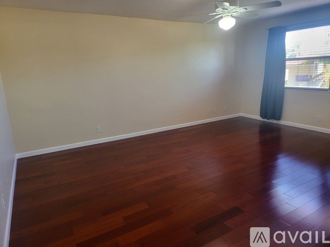 A room with wooden flooring and a ceiling fan.