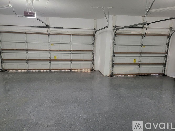 A spacious garage with a concrete floor and multiple white garage doors.
