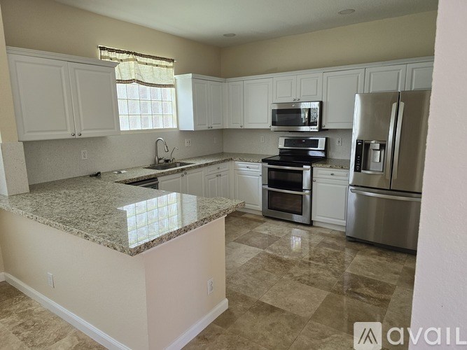 A kitchen with granite countertops and stainless steel appliances.