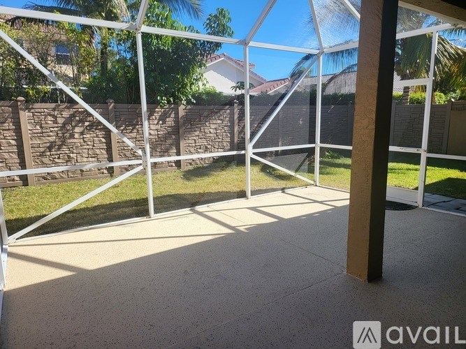 A patio with a white railing and a concrete floor.