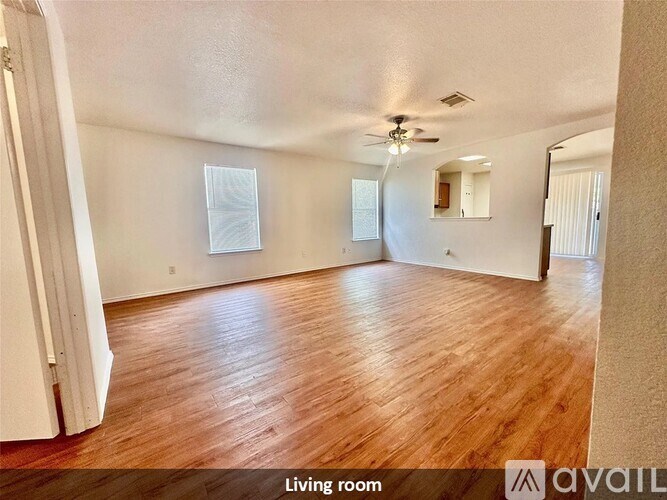A living room with wooden floors and a ceiling fan.