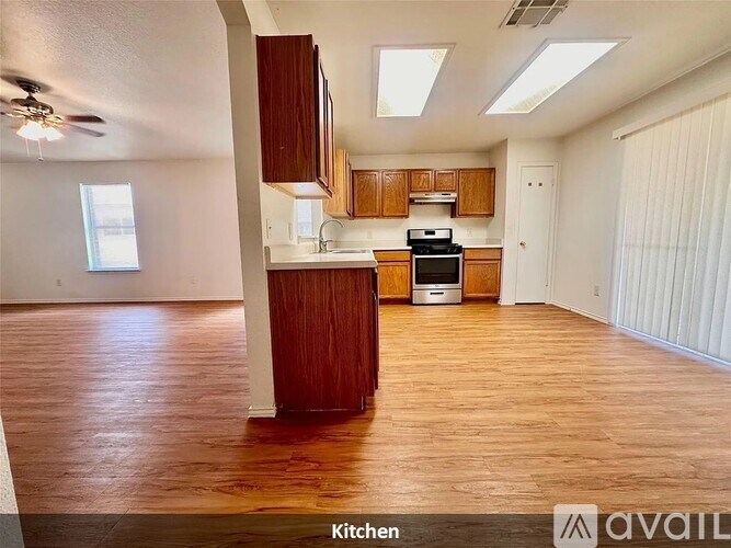 A kitchen with wooden floors and cabinets.