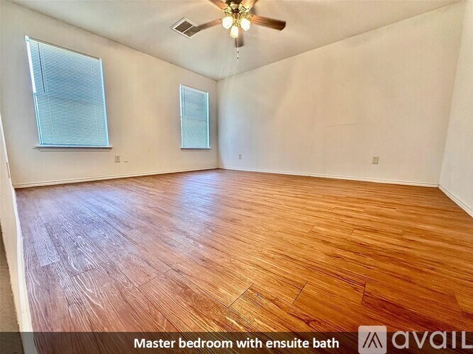 A room with wooden flooring and a ceiling fan.
