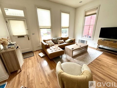 A living room with a brown couch and a white chair.